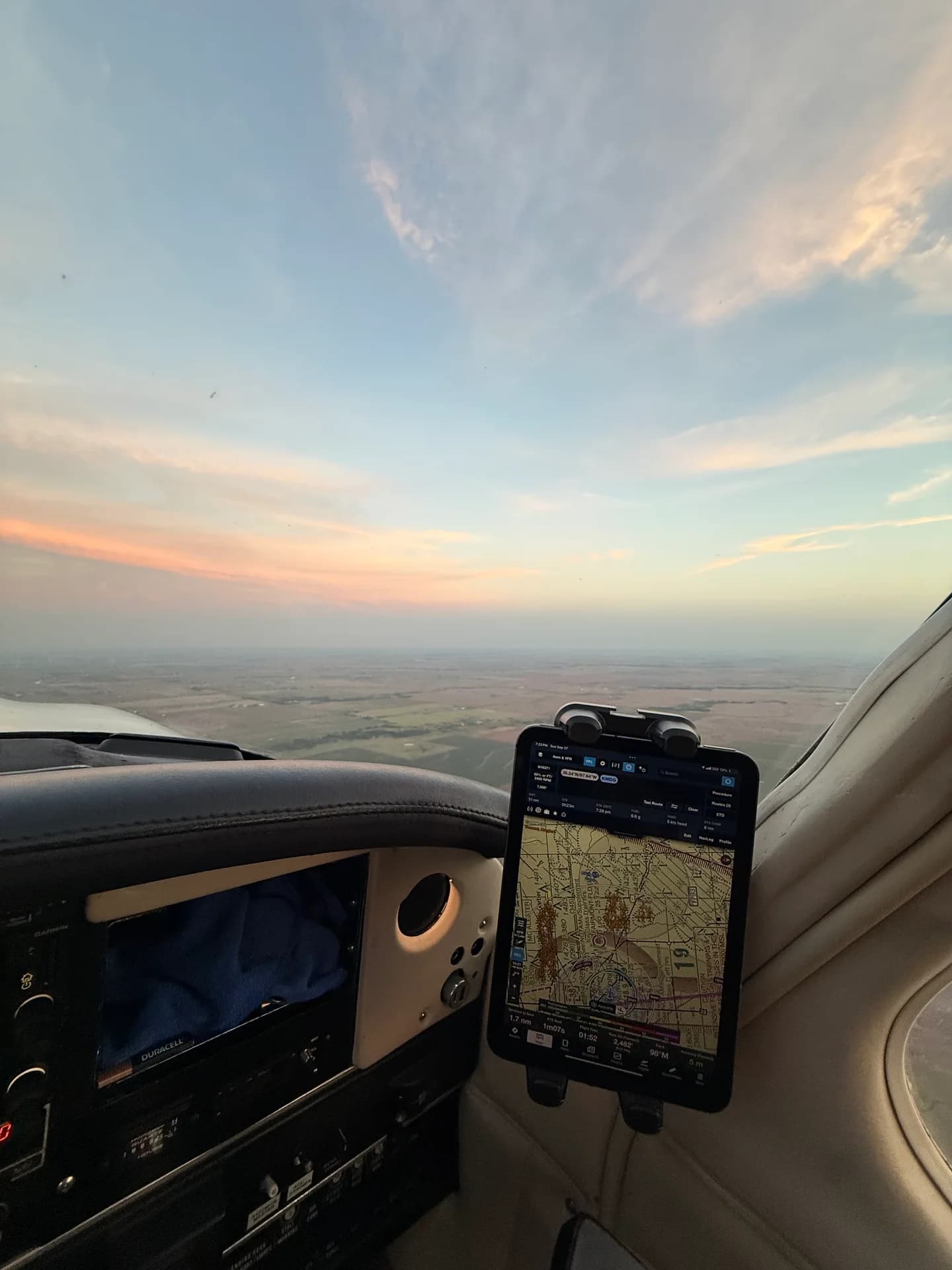 An iPad in a FlightPro spring-loaded holder on a cockpit suction mount, viewed beside the instrument panel.